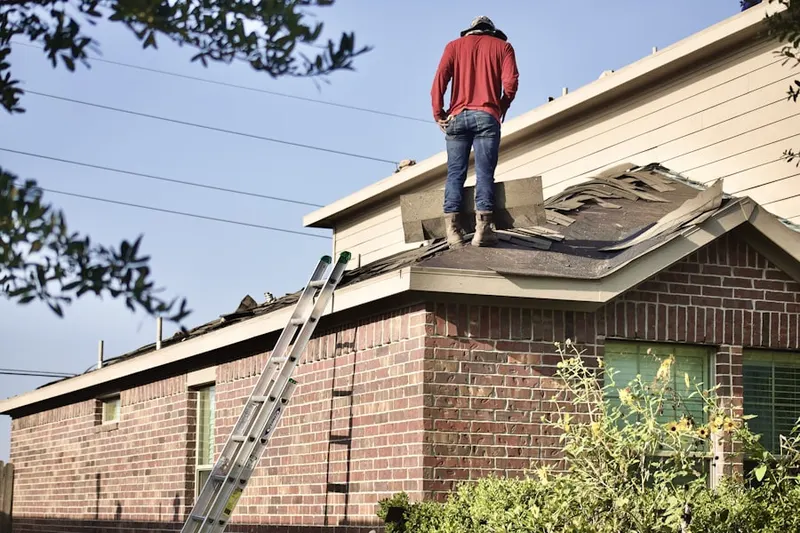 Professional roofer working on a residential roof in Benner